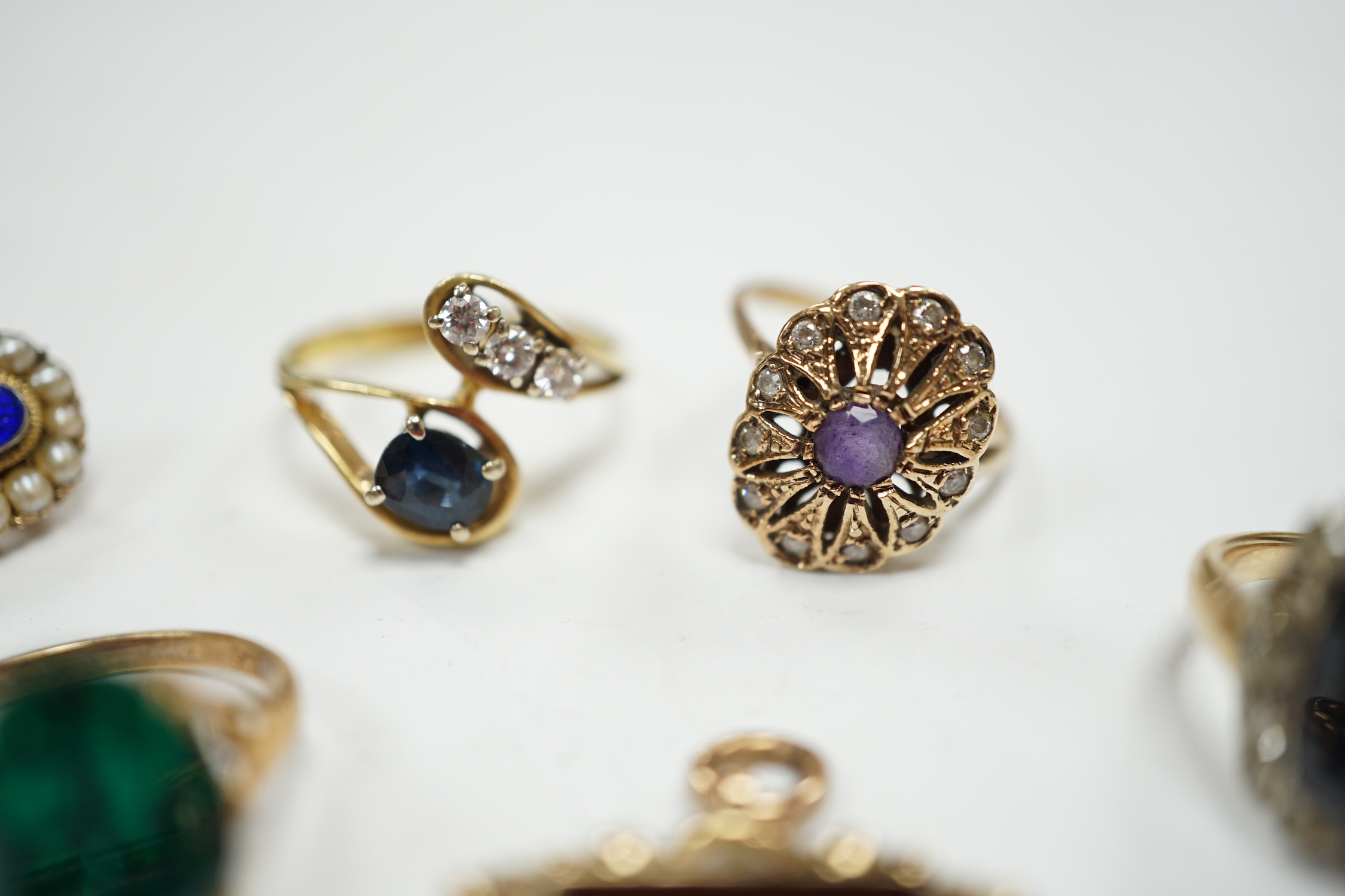 A 750 yellow metal, single stone sapphire and three stone diamond set crossover ring, size, three other yellow metal and gem set rings including a continental 875 white metal and 585 yellow metal, synthetic sapphire or s